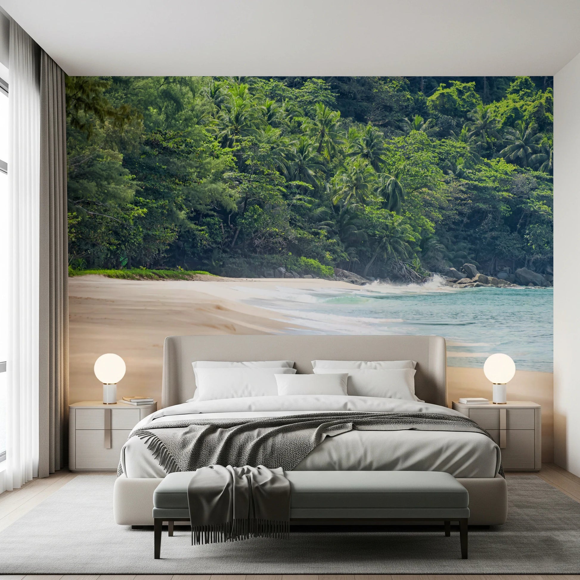 Beach Haven wall mural of a jungle-lined beach behind a beige bed with globe lamps and an upholstered bench