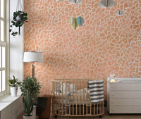 Blush pink mosaic wallpaper mural with geometric white patterns.
