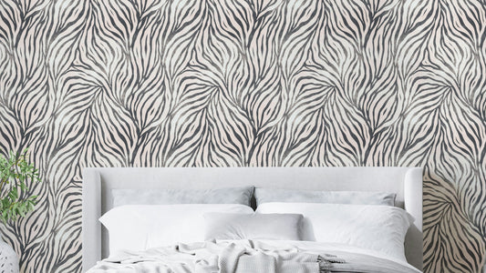Black and White Boho Zebra wallpaper in a bedroom with a grey headboard, white bedding and striped throw