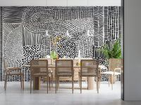 Black And White Maze wallpaper mural behind a wood dining table and cane chairs in a bright room