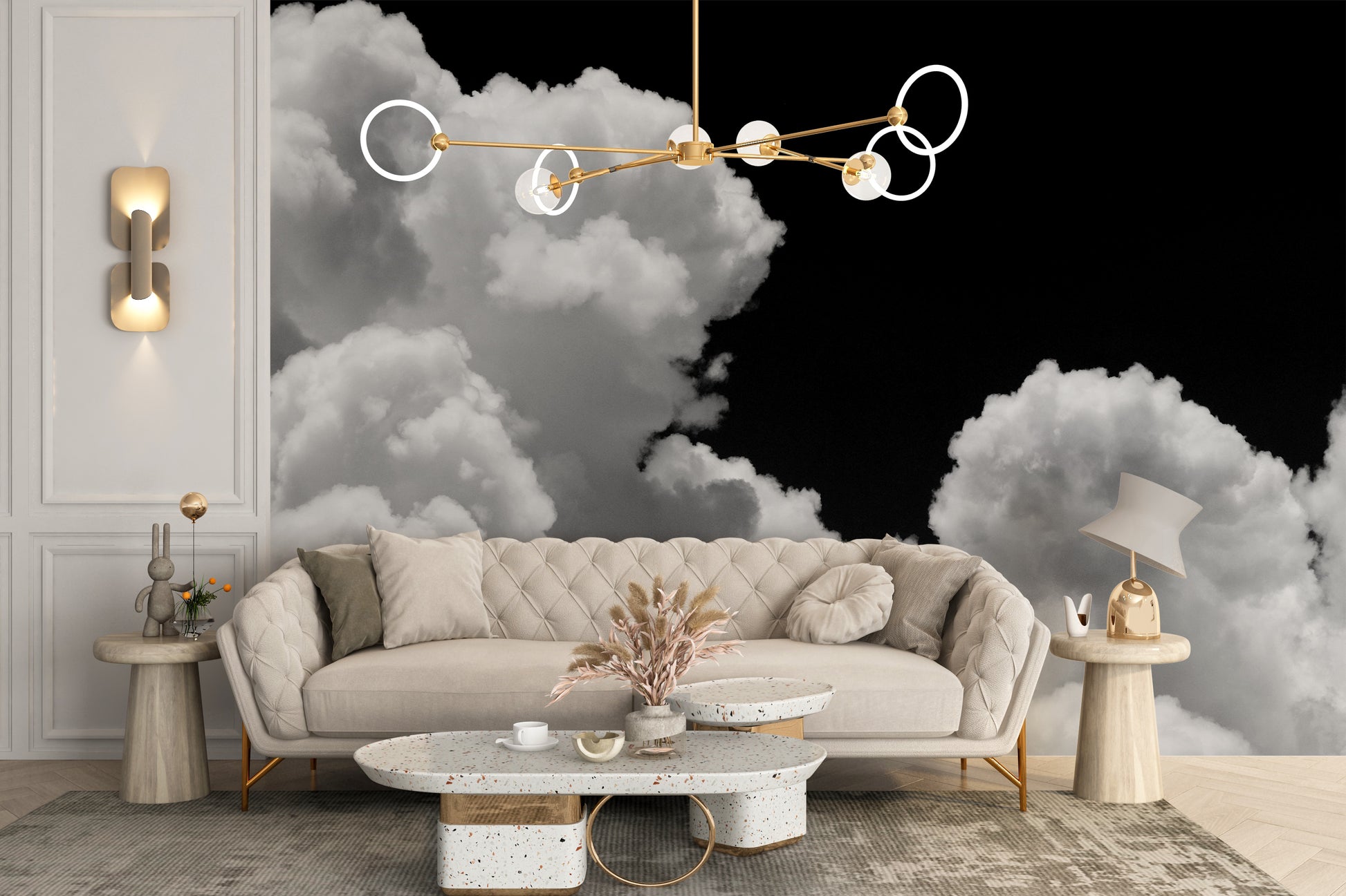 Black and white Clouds mural of white clouds on black behind a cream tufted sofa and terrazzo coffee table