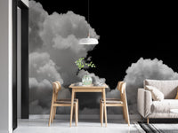 Black and white Clouds mural of white clouds on a black sky in a dining nook with a light wood table and chairs