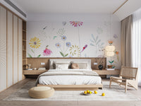 Bloom and Bird wallpaper mural of watercolor flowers above a low wood platform bed and rattan chair in a bedroom