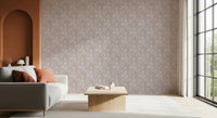 Bloomscape Beige wallpaper beside a terracotta arch behind a grey sofa with rust cushions in a living room