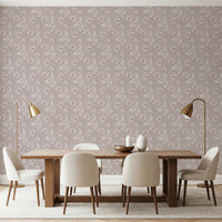 Bloomscape Beige wallpaper in dusty-pink blooms behind a wood dining table and cream chairs with brass lamps