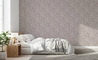 Bloomscape Beige wallpaper in dusty-pink florals behind a low white bed and wood nightstand in a sunlit bedroom