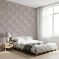 Bloomscape Beige wallpaper in mauve blooms behind a white platform bed by a sheer-curtained window in a bedroom