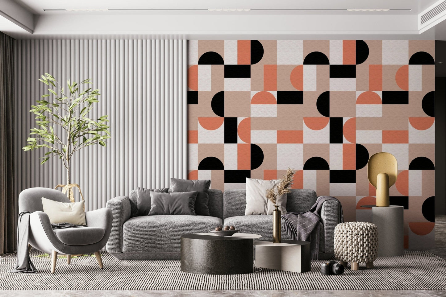 Blush Geometry wallpaper with pink and black shapes behind a grey sofa and armchair in a modern living room
