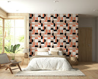 Blush Geometry wallpaper in pink and black above a bed with rattan bench in a wood-panelled bedroom