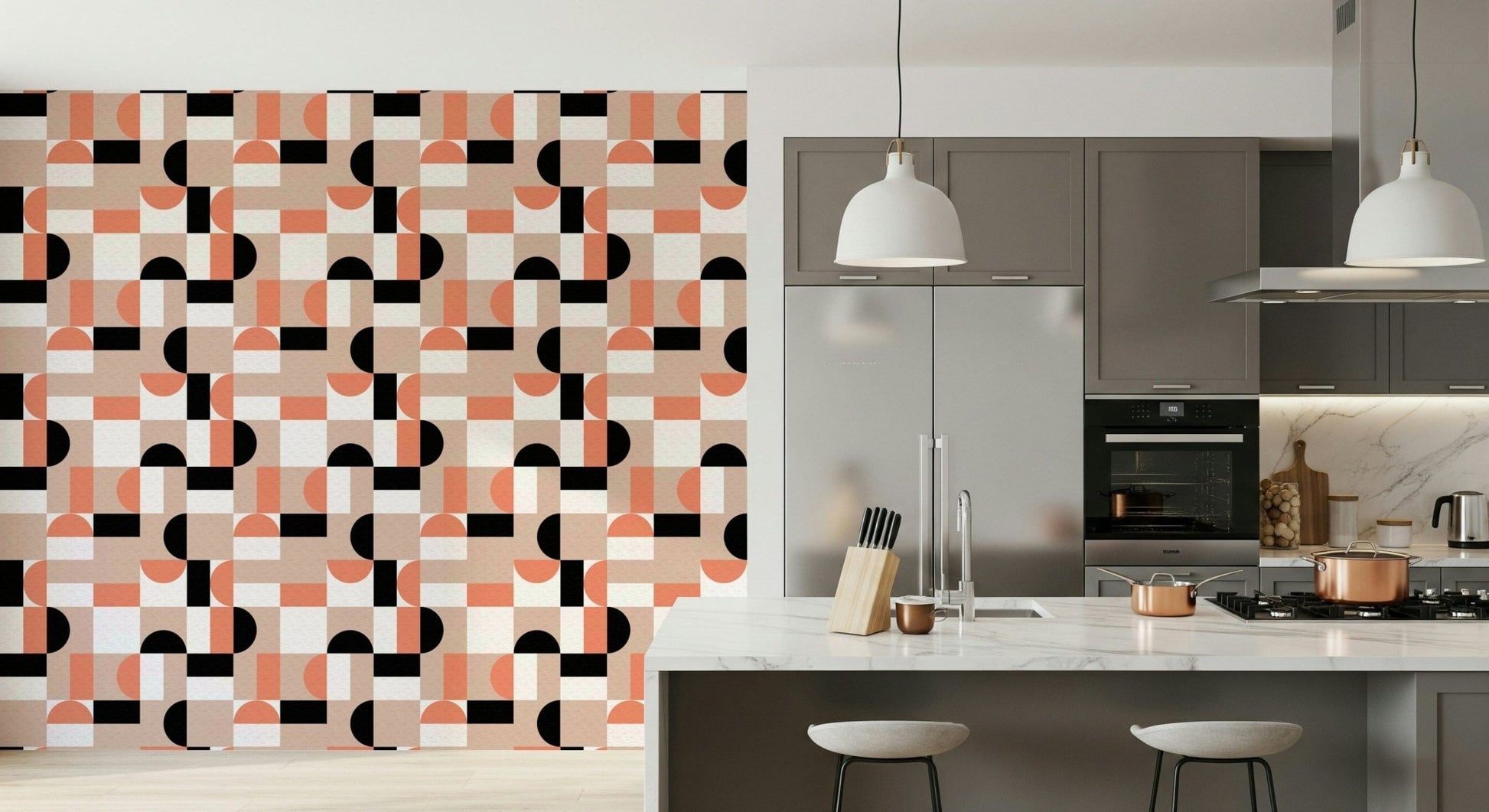 Blush Geometry wallpaper in coral and black on a kitchen wall beside grey cabinets and a marble island
