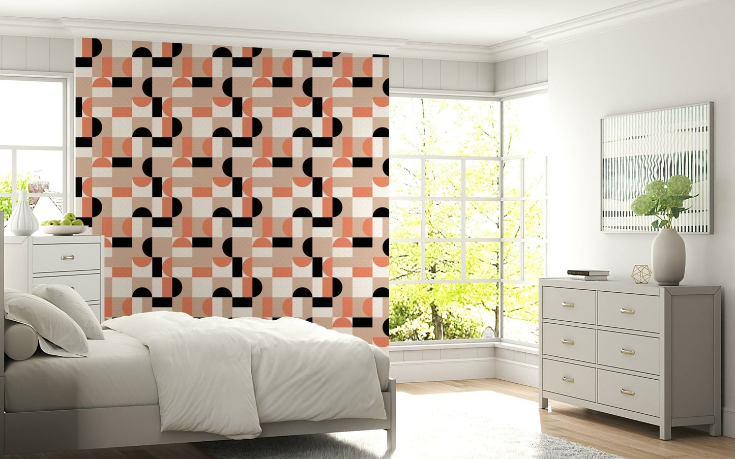 Blush Geometry wallpaper in coral and black behind a white bed and grey dresser in a sunny bedroom