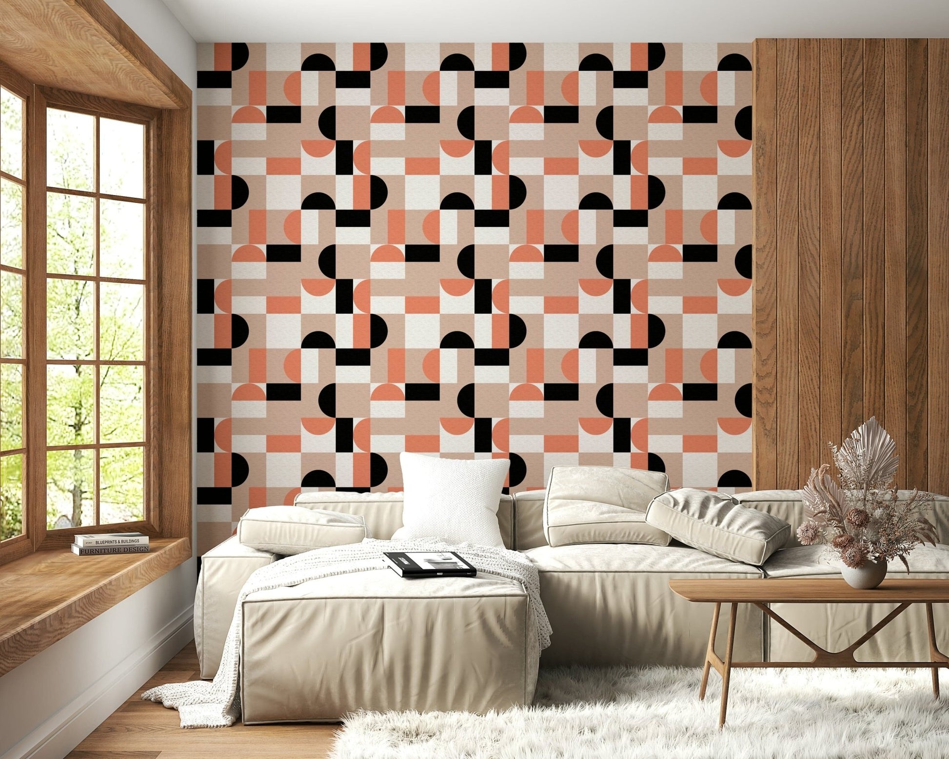 Blush Geometry wallpaper in coral and black on a wood-accent wall behind a beige sectional sofa in a living room