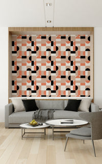 Blush Geometry wallpaper in pink and black framed in a wood niche above a grey sofa in a living room
