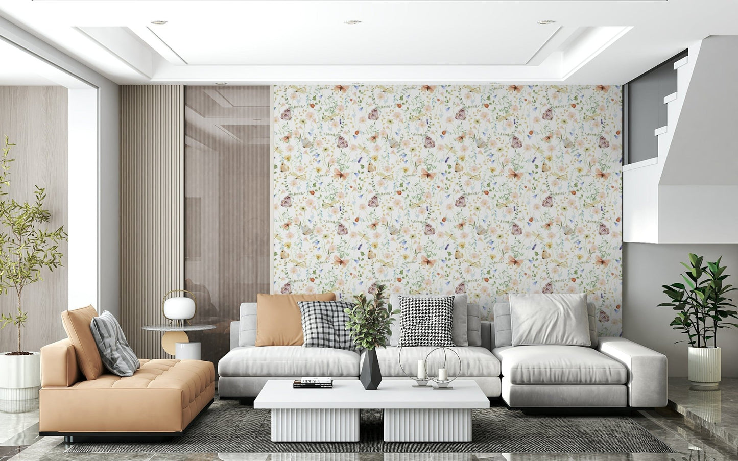 Blush Meadow's Whisper wallpaper of soft blooms behind a grey sectional sofa and tan leather chaise in a living room