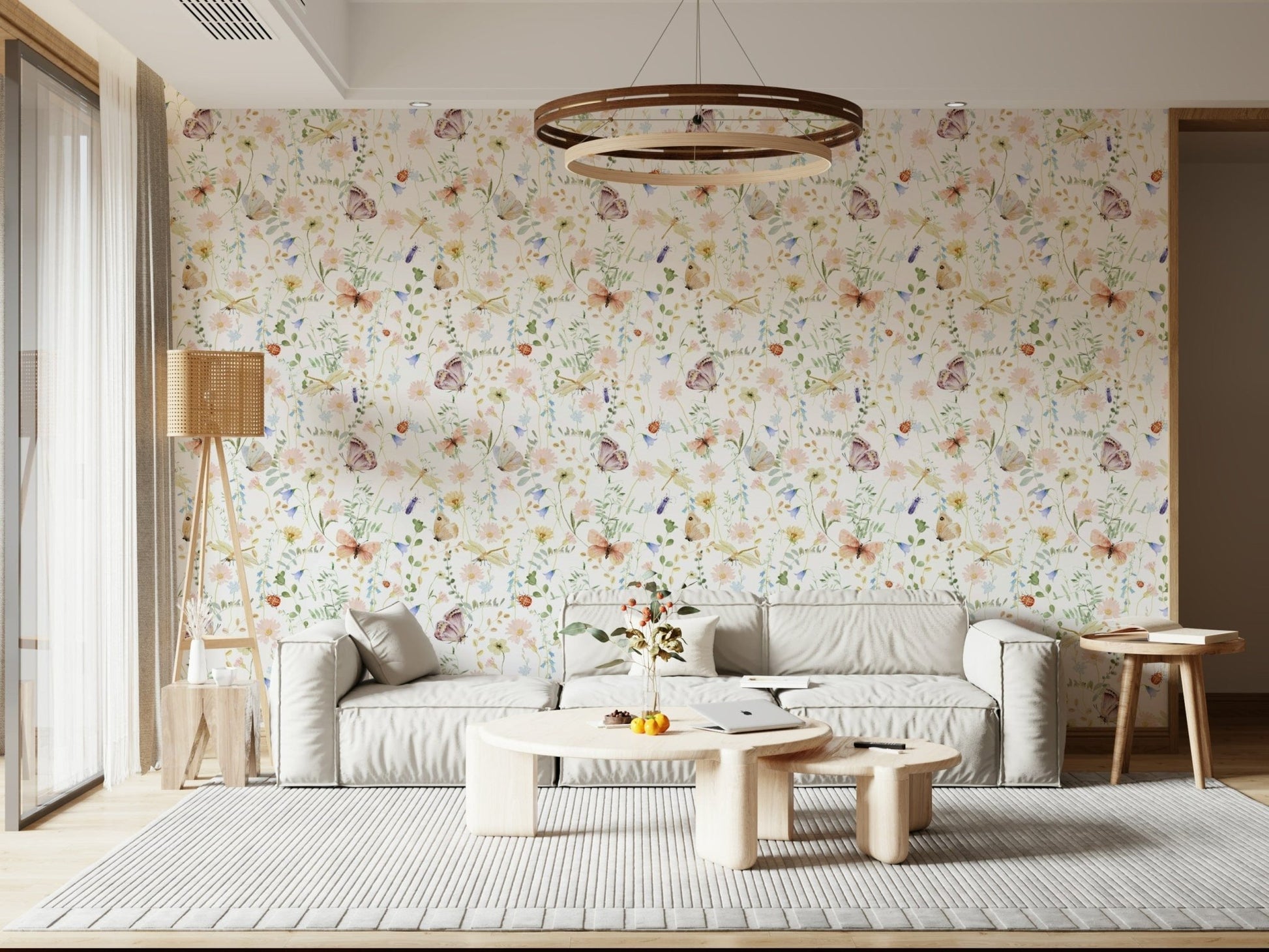 Blush Meadow's Whisper wallpaper of blush wildflowers behind a low grey sofa with a round wood chandelier