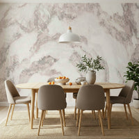 Blush Stone Texture wallpaper mural in blush marble behind an oval wood dining table with taupe chairs and pendant