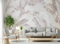 Blush Stone Texture wallpaper mural in pink marble behind a grey sectional with mustard and navy pillows
