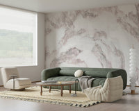 Blush Stone Texture wallpaper mural in pink-veined marble behind a green sofa and cream lounge chair in a living room