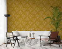 Boho Art Nouveau Folk Floral Mustard Gold wallpaper behind a white sofa and leather chair in a chic living room