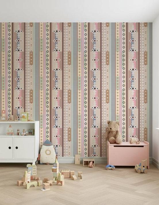 Boho Aztec wallpaper with pastel pink and sage striped tribal pattern in a nursery with a white dresser and teddy bear