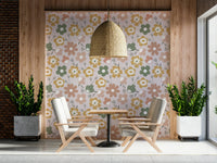 A boho-inspired wallpaper with oversized daisy shapes in earthy pink, yellow, and sage hues.