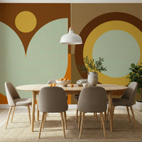 Boho Sun and Moon wallpaper mural with rust, sage and yellow geometric shapes in a dining room with taupe chairs and a wood table