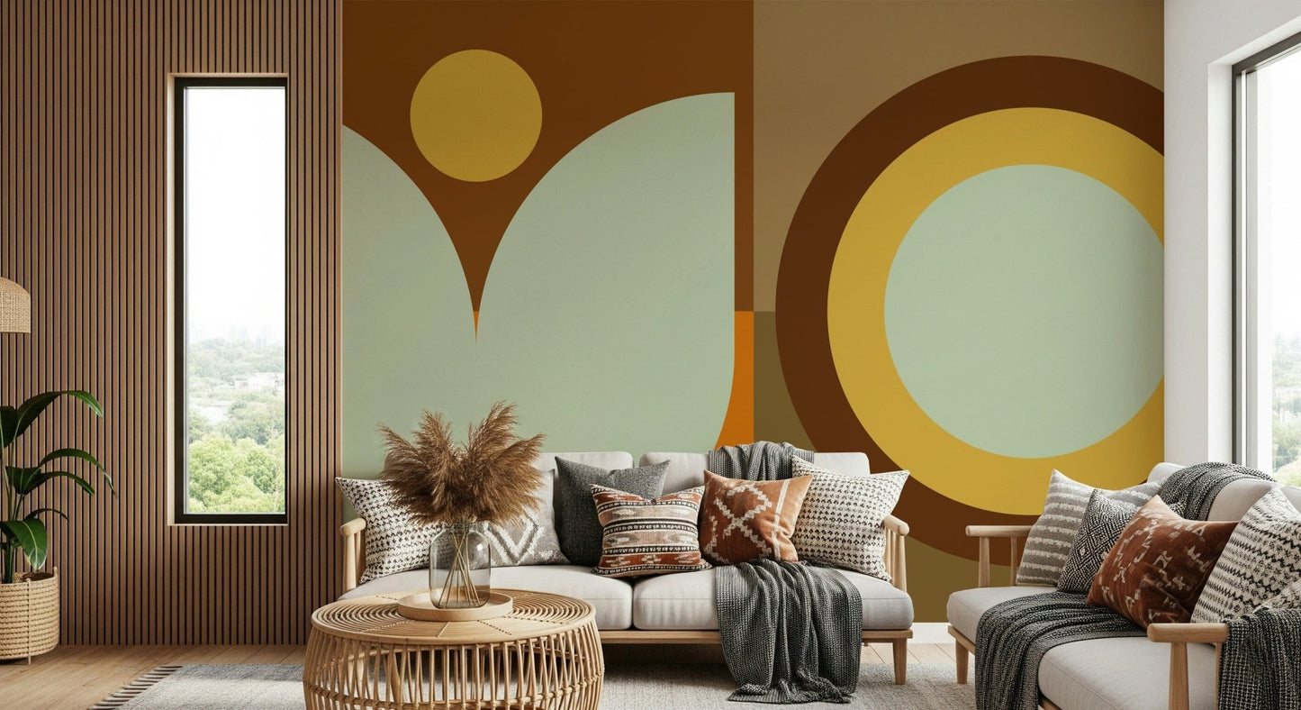 Boho Sun and Moon wallpaper mural with brown and sage shapes behind a cream sofa with boho pillows by a wood-slat wall