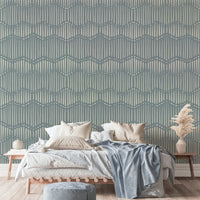 Boho Waves On Arona Canvas wallpaper in slate blue behind a wood platform bed with beige bedding and pampas grass