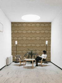 The mural is installed in a calm, bohemian living room behind a simple, light-colored sofa.

