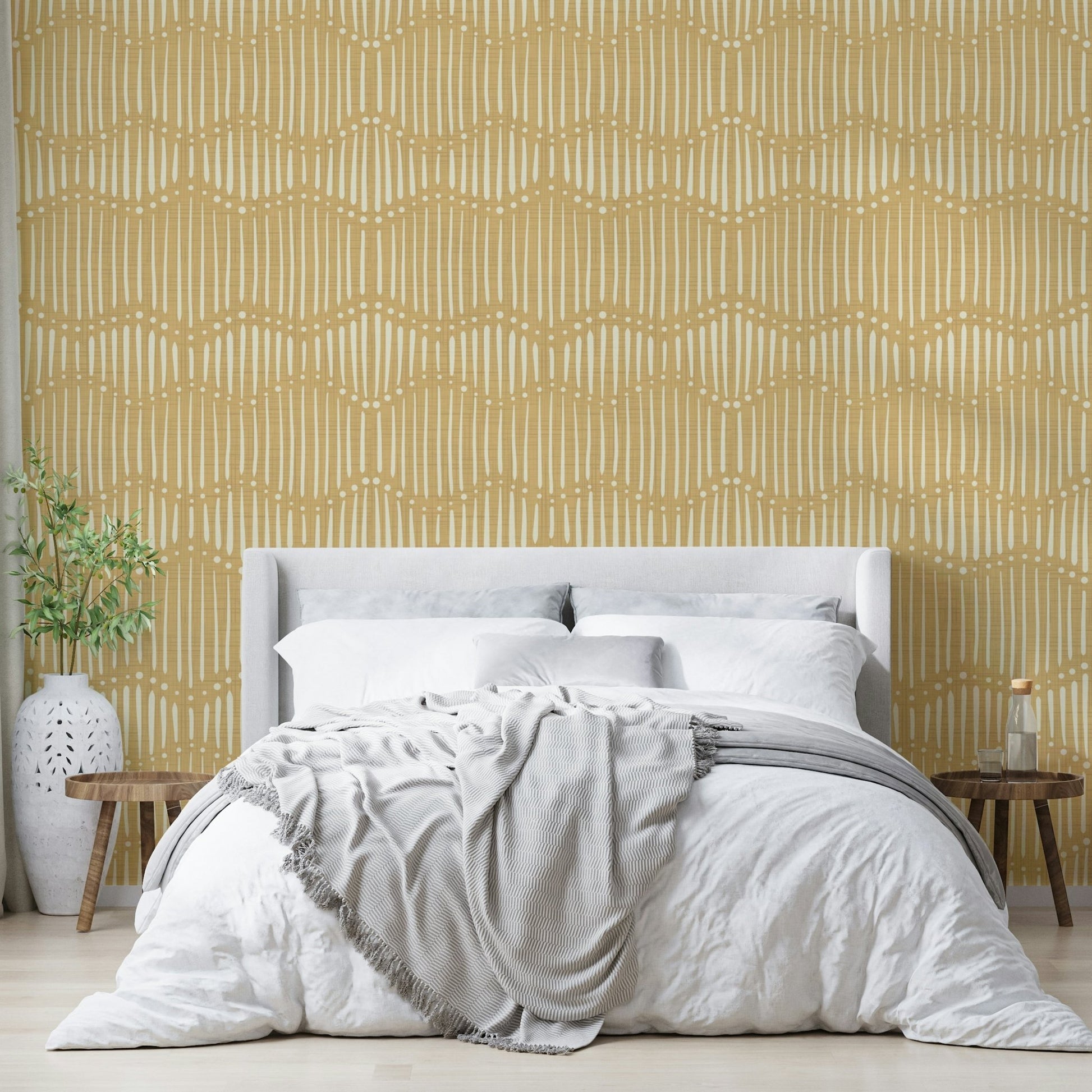 The mural is installed in a calm, bohemian living room behind a simple, light-colored sofa.

