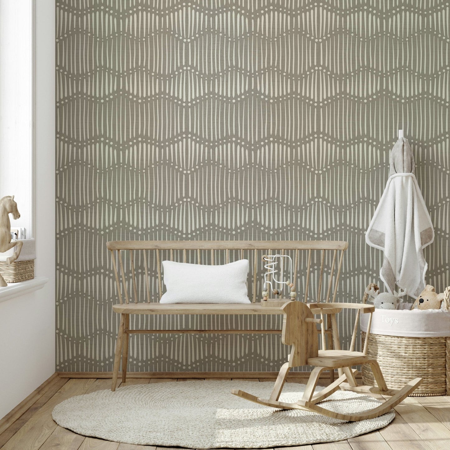 The mural is installed in a calm, bohemian living room behind a simple, light-colored sofa.


