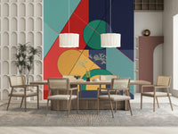 Bold Bauhaus wallpaper mural of red and teal shapes behind a wood dining table with cane chairs