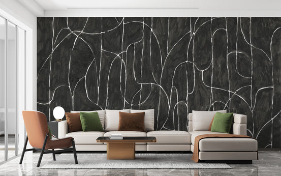 Boulder Beach Black wallpaper mural in textured black with white abstract lines behind a cream sectional in a living room