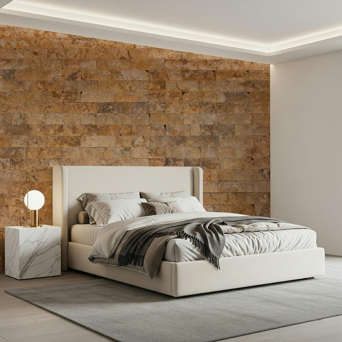 Brickwork Beauty wallpaper mural in amber stone behind a cream upholstered bed and marble nightstand