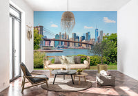 Bridge to Manhattan wall mural of the bridge and skyline behind a rattan bench sofa on a terracotta-tiled floor
