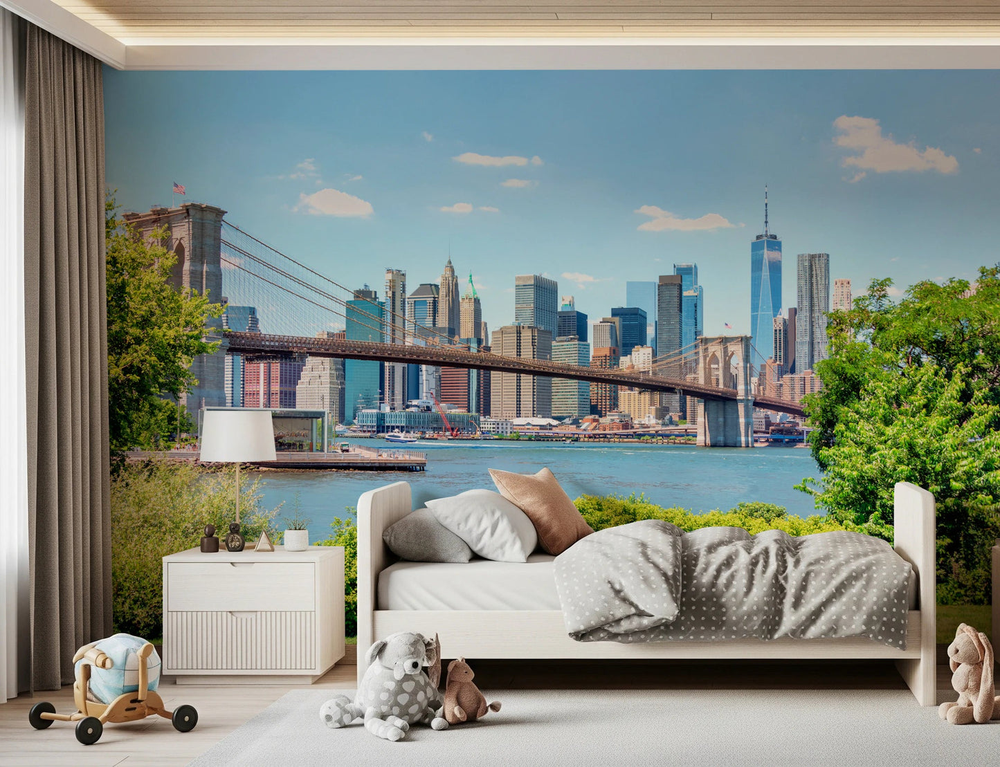 Bridge to Manhattan wall mural of the bridge and blue skyline in a kids room with a white bed and plush toys