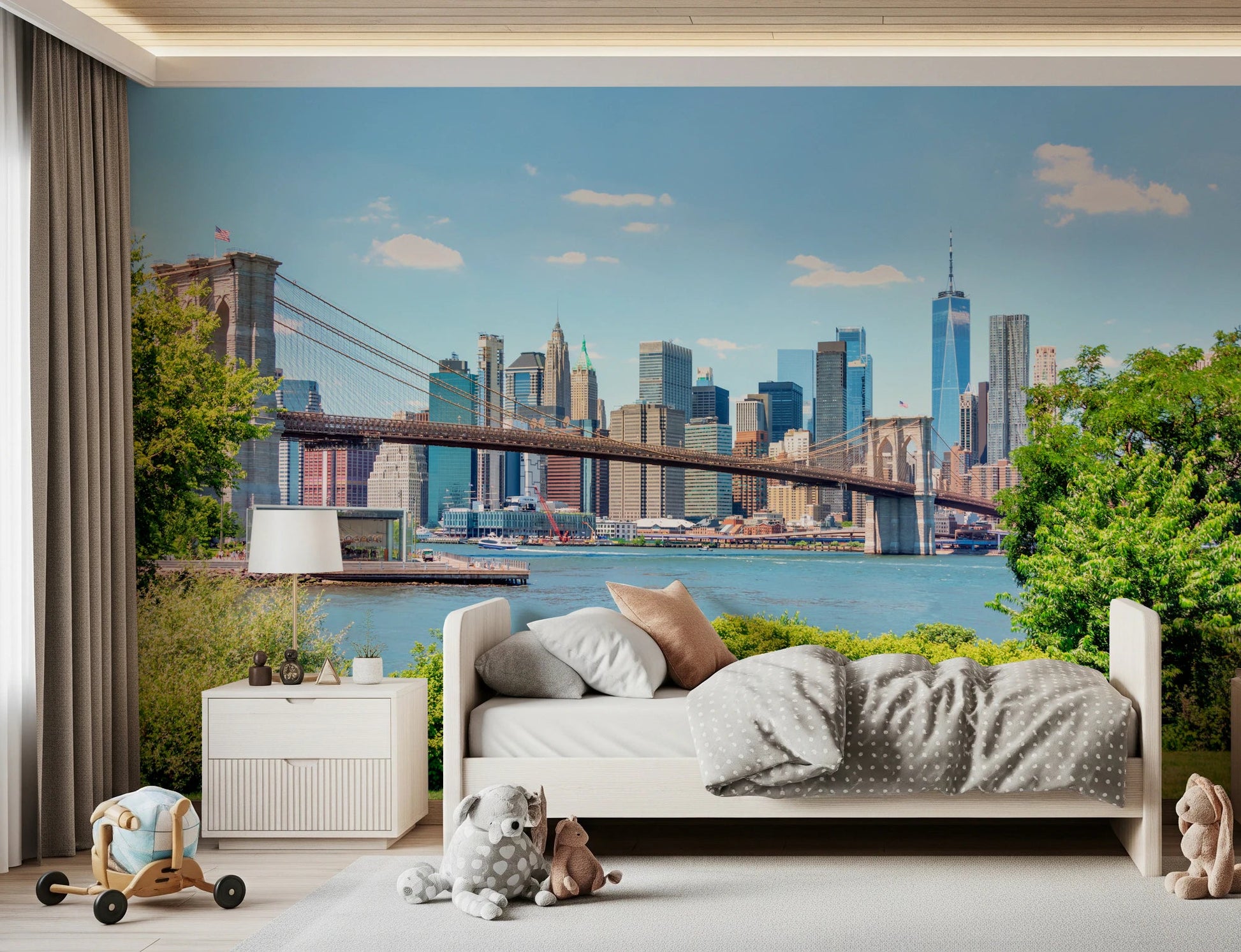 Bridge to Manhattan wall mural of the bridge and blue skyline in a kids room with a white bed and plush toys