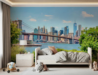 Bridge to Manhattan wall mural of the bridge and blue skyline in a kids room with a white bed and plush toys
