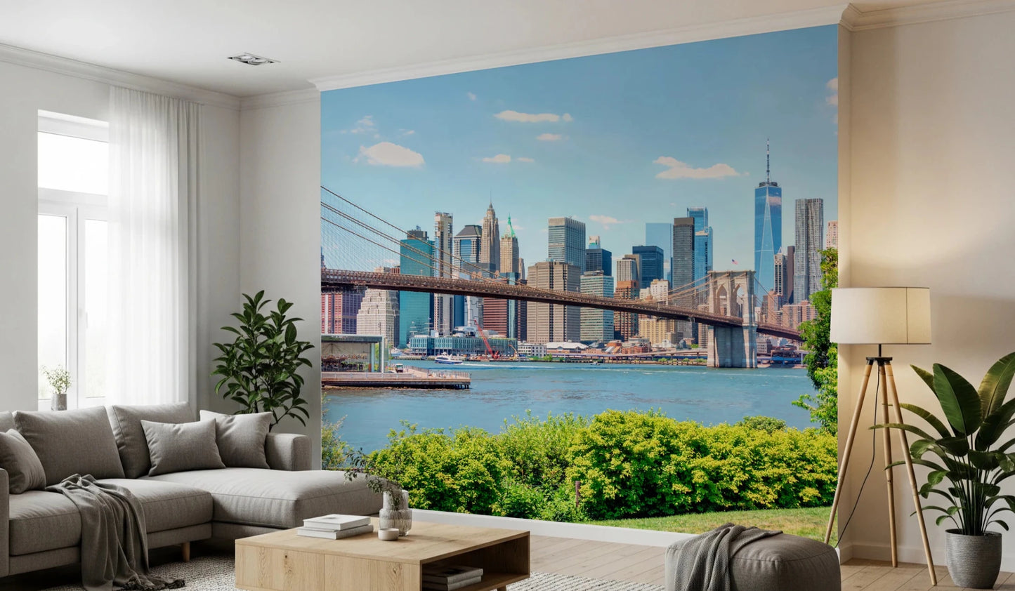 Bridge to Manhattan wall mural of the bridge and skyline over blue water behind a grey sofa and tripod lamp