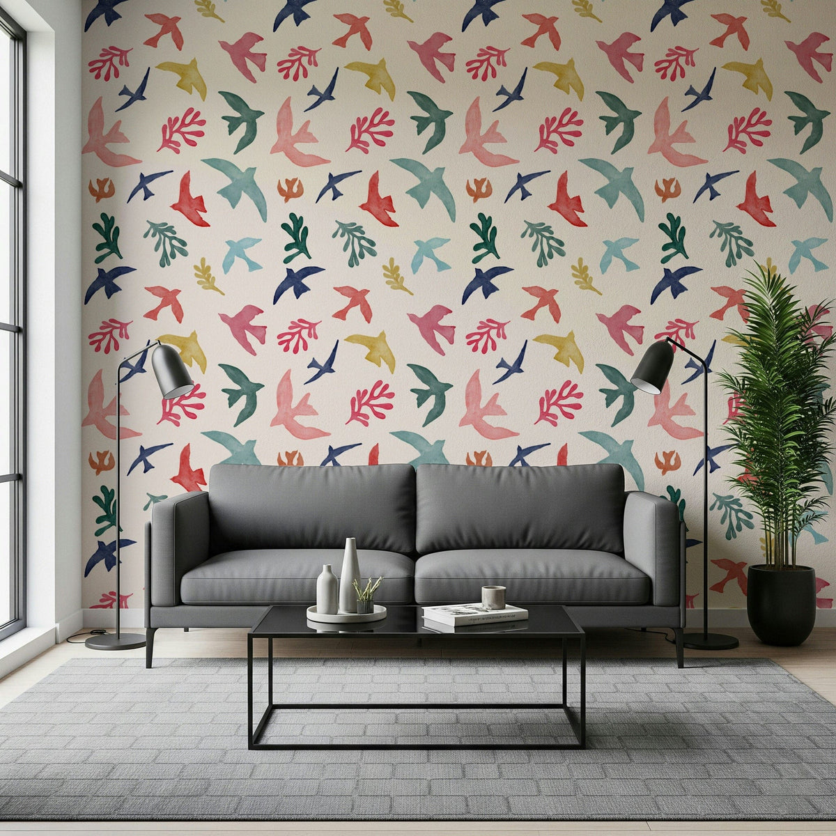 Bright Freedom Birds wallpaper behind a grey sofa with two black floor lamps in a living room