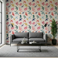 Bright Freedom Birds wallpaper behind a grey sofa with two black floor lamps in a living room