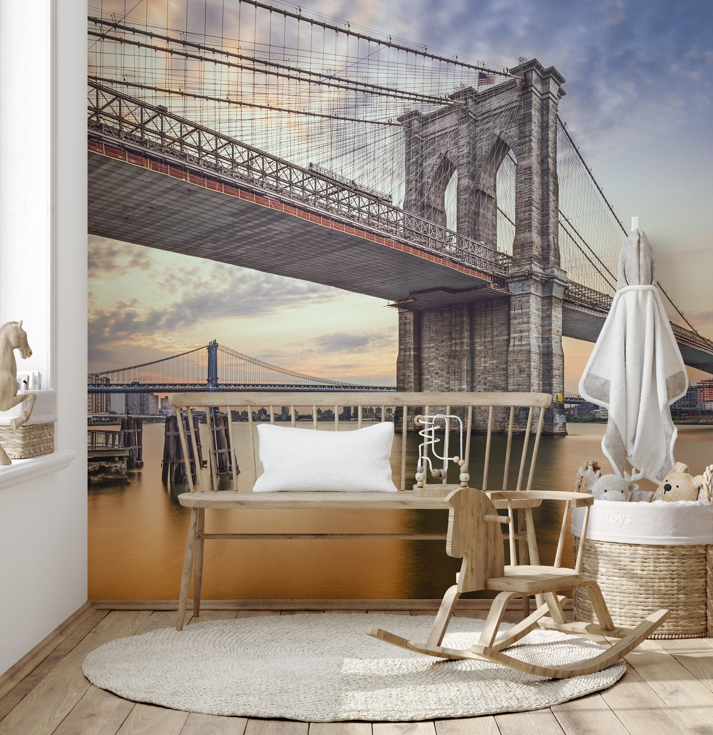 Brooklyn Bridge New York City wallpaper mural at dusk behind a wooden bench and rocking chair in a nursery