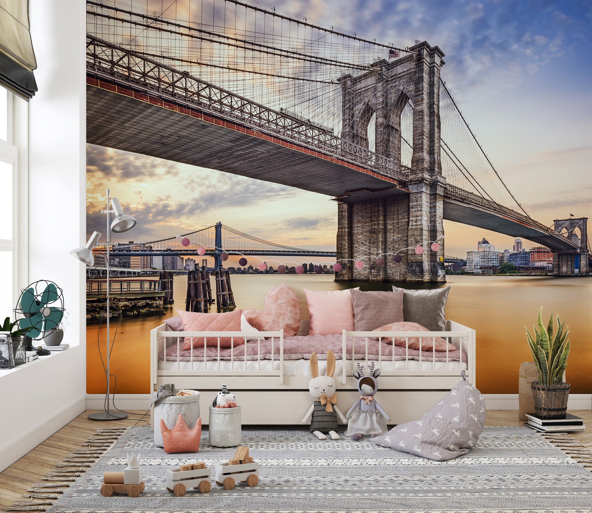 Brooklyn Bridge New York City wallpaper mural over the river behind a white daybed with pink cushions in a kids room
