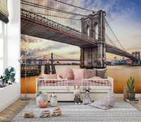 Brooklyn Bridge New York City wallpaper mural over the river behind a white daybed with pink cushions in a kids room