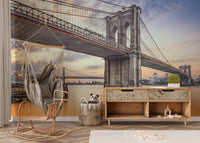 Brooklyn Bridge New York City wallpaper mural at sunset above a wooden media console and hanging chair in a kids room