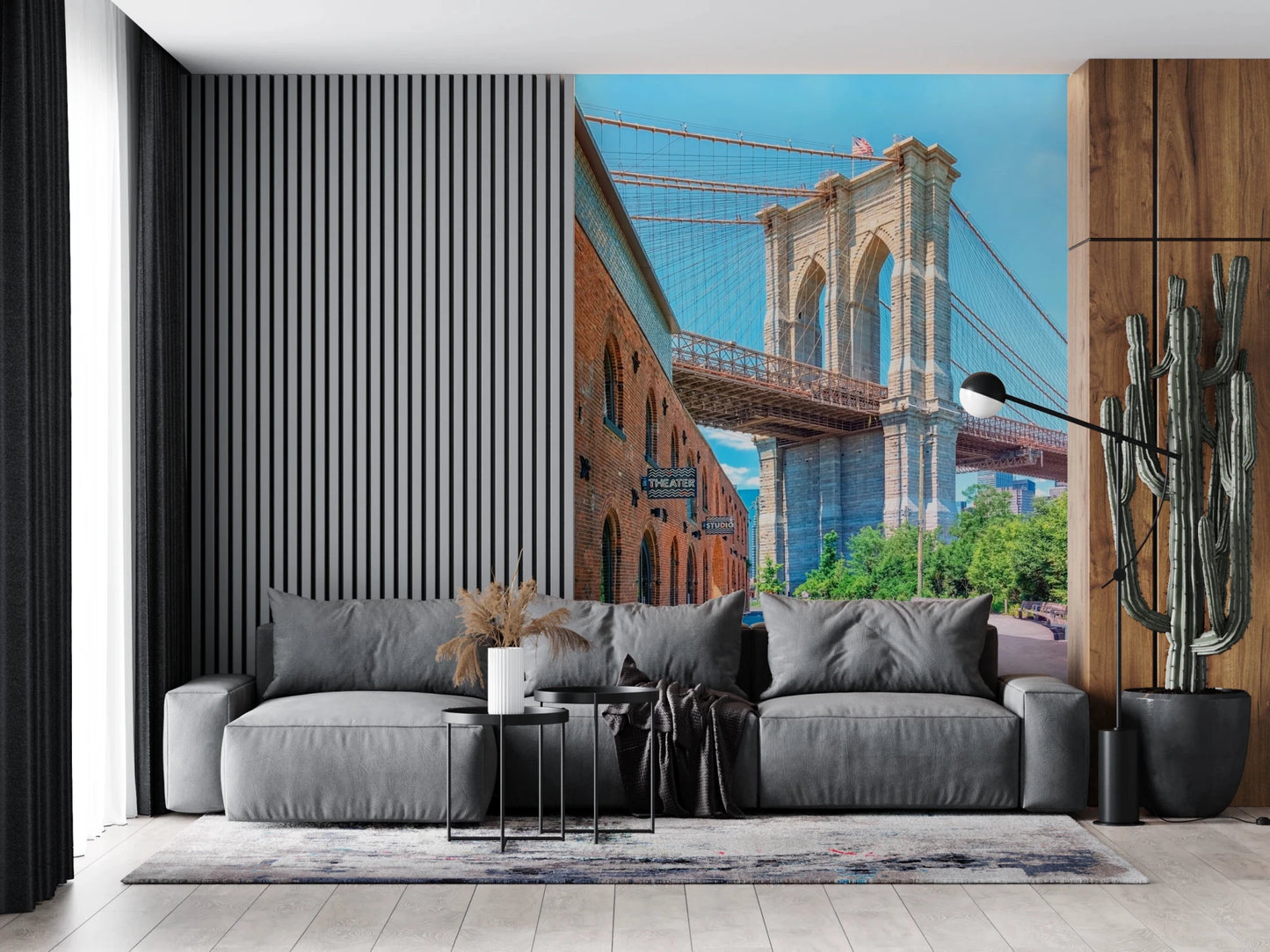 Brooklyn Bridge Vista wallpaper mural of the stone tower and warehouse above a grey sofa with a tall cactus in a living room