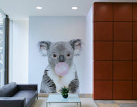 Whimsical koala with bubble gum captured in a vibrant wall mural.

