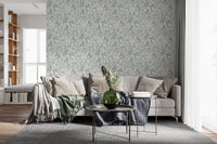 Butterfly Bloom Line Art wallpaper behind a beige sectional with protea blooms and dark round tables