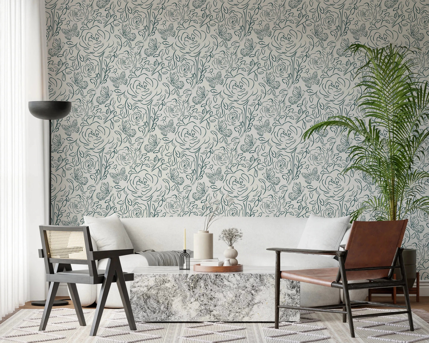 Butterfly Bloom Line Art wallpaper behind a white sofa with marble table, cane chair and tall palm