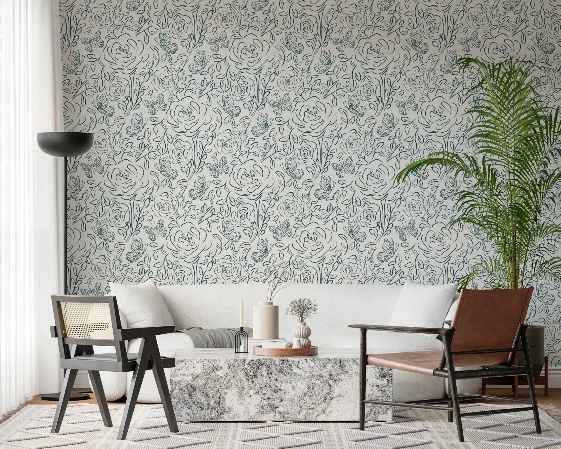 Butterfly Bloom Line Art wallpaper behind a white sofa with marble table, cane chair and tall palm